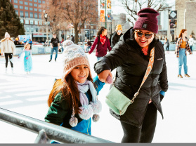 Mom and daughter holding hands while ice skating