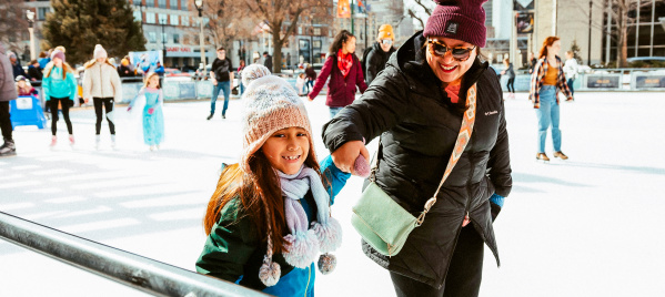 Mom and daughter holding hands while ice skating