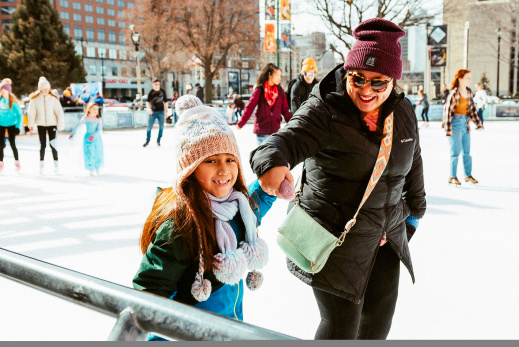 Mom and daughter holding hands while ice skating
