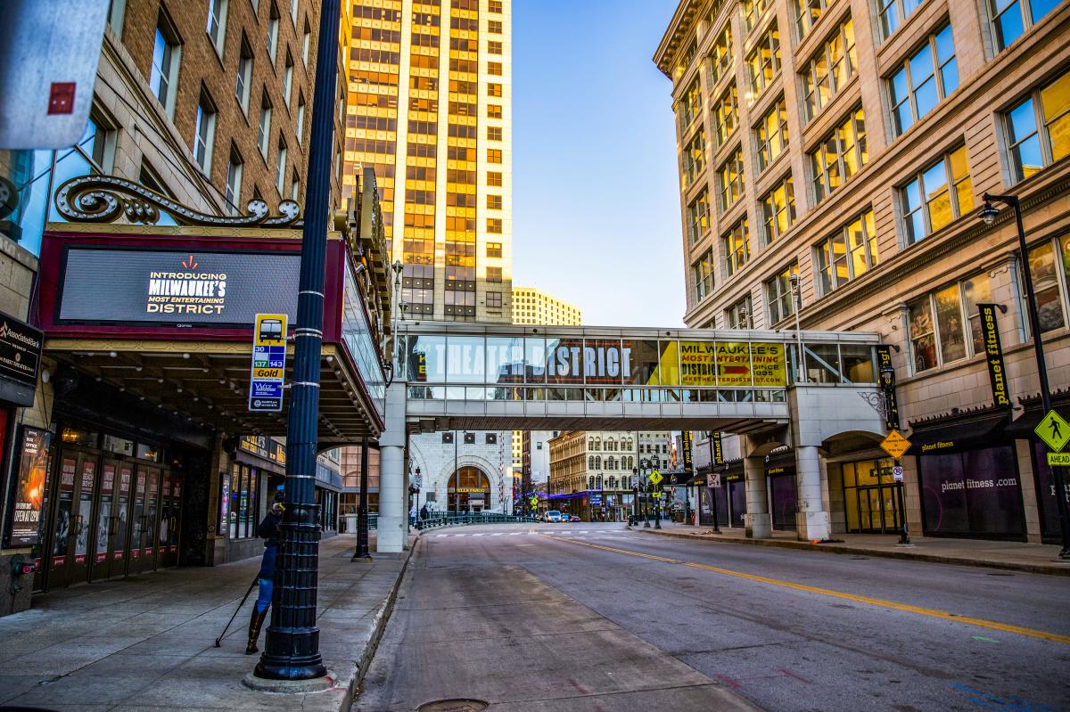 an image of a city street with a theater marquee and a skywalk with Milwaukee Theater District branding