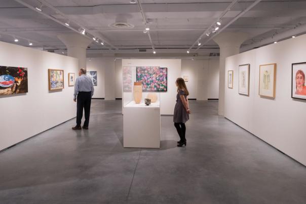 Two people observing art at The Warehouse Art Museum