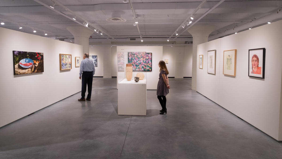 Two people observing art at The Warehouse Art Museum