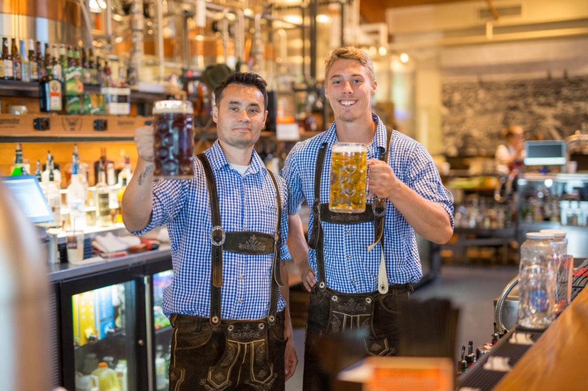 Two men in lederhosen holding liter steins of beer at the Bavarian Bierhaus