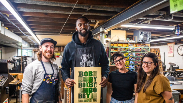 Bobby Portis with the Bay View Printing Co. team, holding his custom printed poster