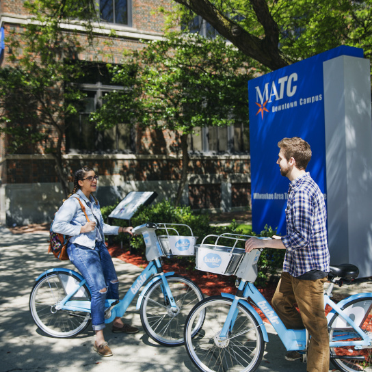 two college students by MATC campus on bublr bikes
