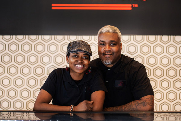Delicious Bites Owners smiling behind treat counter