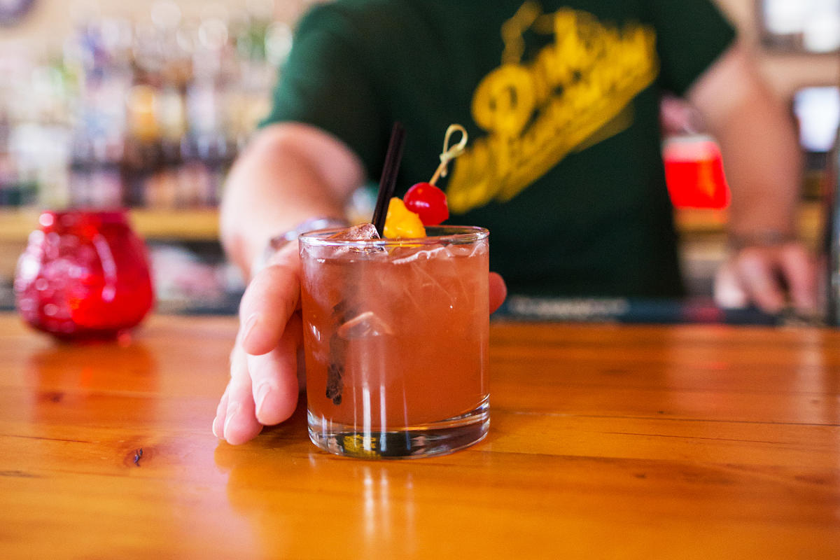 bartender offering old fashioned at bar