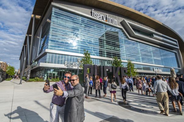 meeting attendees taking a selfie in front of Fiserv Forum during Northwestern Mutual's annual meeting