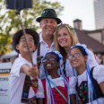 a family taking a selfie with a selfie stick in traditional German attire on festival grounds