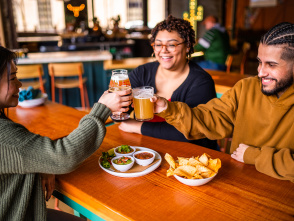 smiling friends cheersing at table