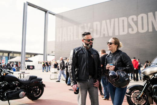 Bikers talking and smiling in front of the Harley Davidson Museum
