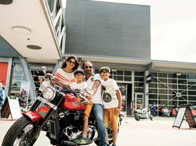 family of four on and around a Harley Davidson Motorcyle