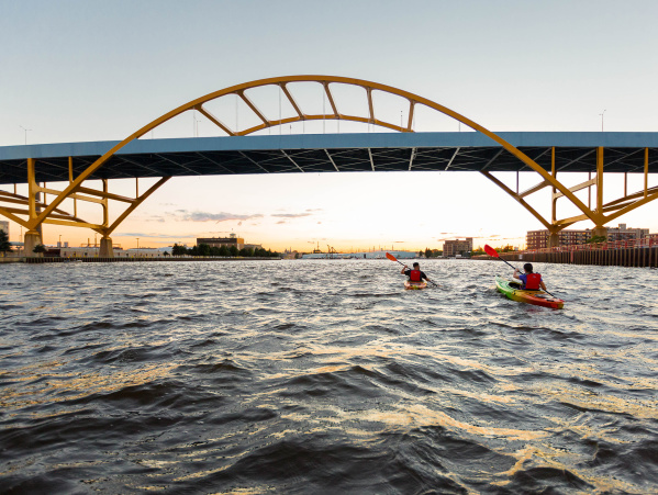 two kayakers kayaking under the Hoan Bridge