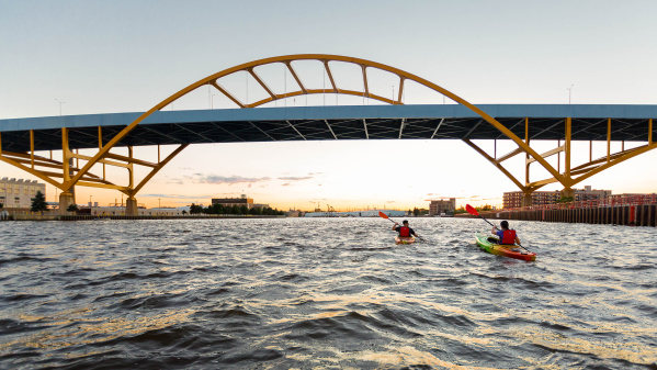 two kayakers kayaking under the Hoan Bridge