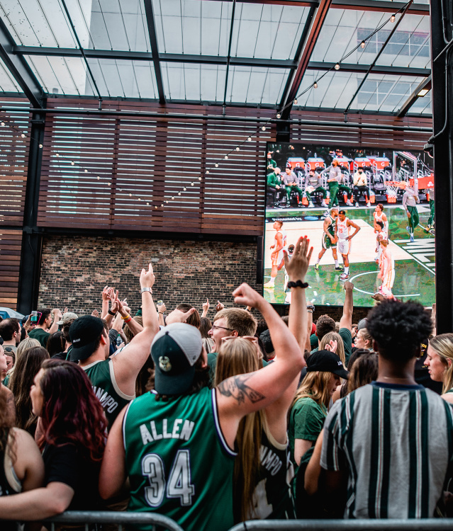 crowd of people watching and cheering on bucks in a beer garden