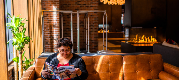 visitor reading the Official Visitors Guide in the lobby of the Journeyman Kimpton Hotel