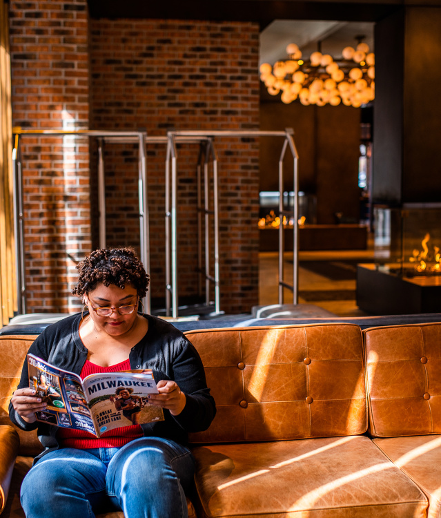 visitor reading the Official Visitors Guide in the lobby of the Journeyman Kimpton Hotel