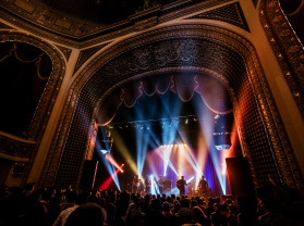 inside view of the Pabst Theater with concert ongoing, bright lights, crowd