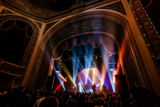 inside view of the Pabst Theater with concert ongoing, bright lights, crowd