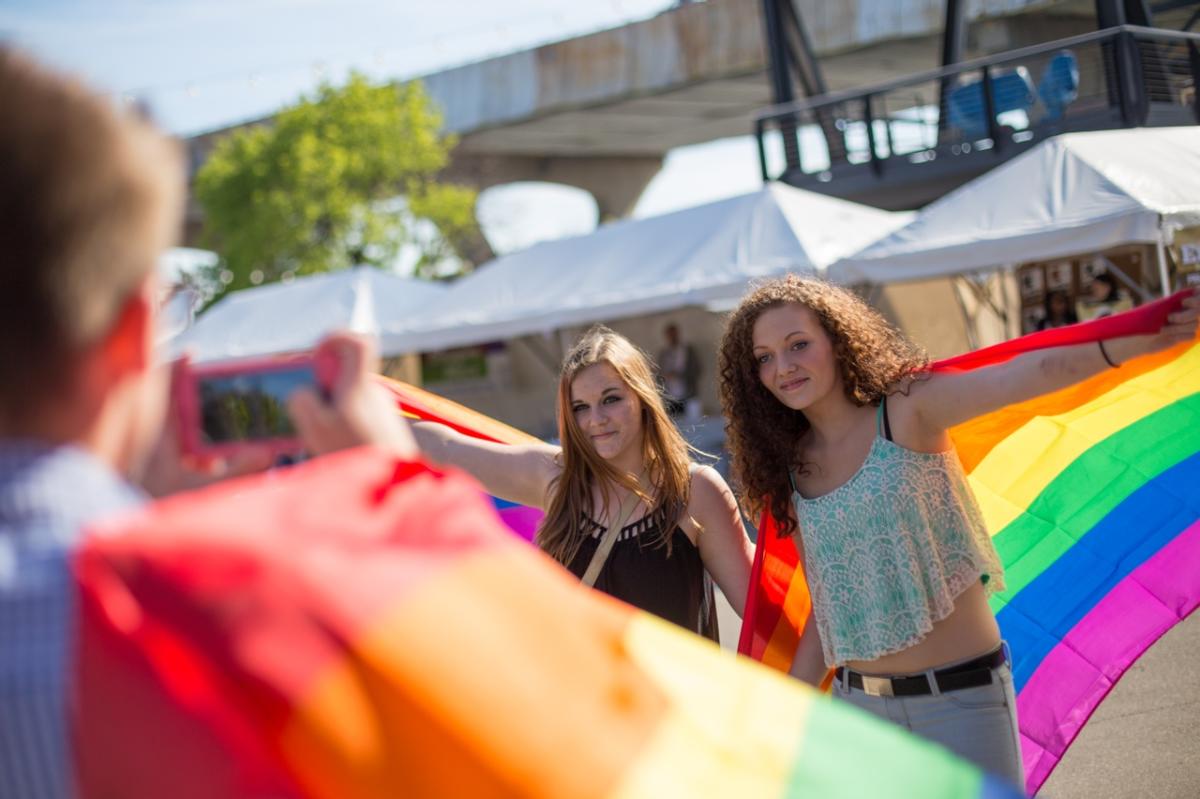 Two people holding pride flags at PrideFest