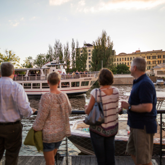 people looking at the VistaKing ship on the river in the Third Ward