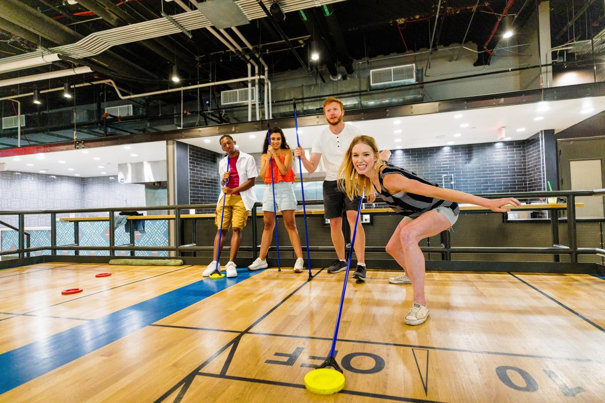 group of friends playing shuffleboard