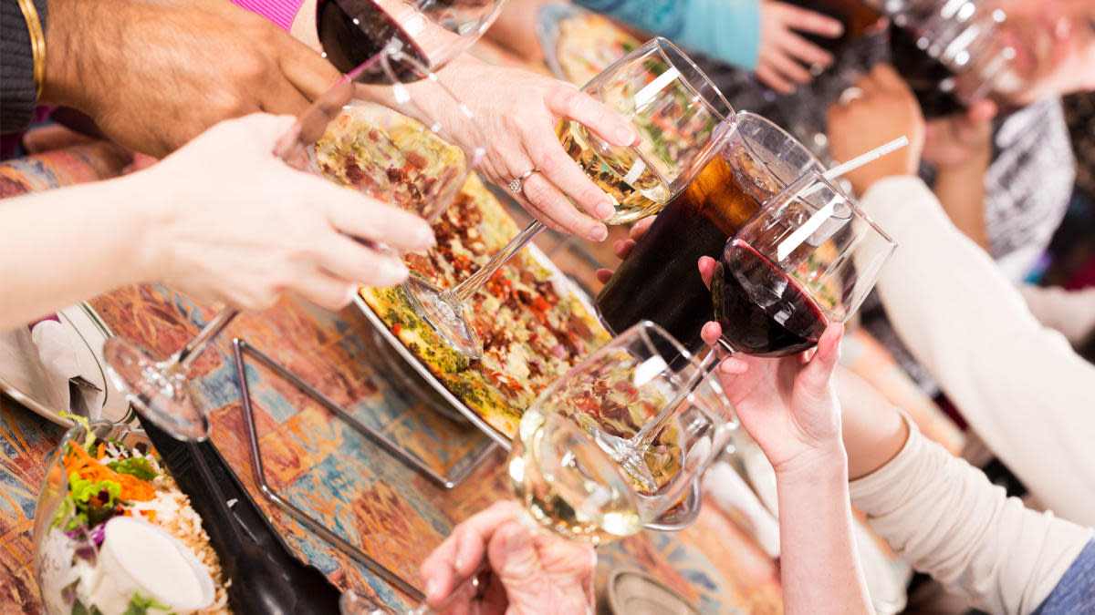 Image six people toasting various wines over a pizza at Transfer Pizzeria