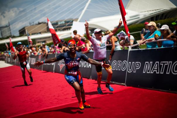 triathlete crossing the finish line in front of the Milwaukee Art Museum at the 2022 USA Triathalon