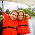 two friends smiling on swan boats