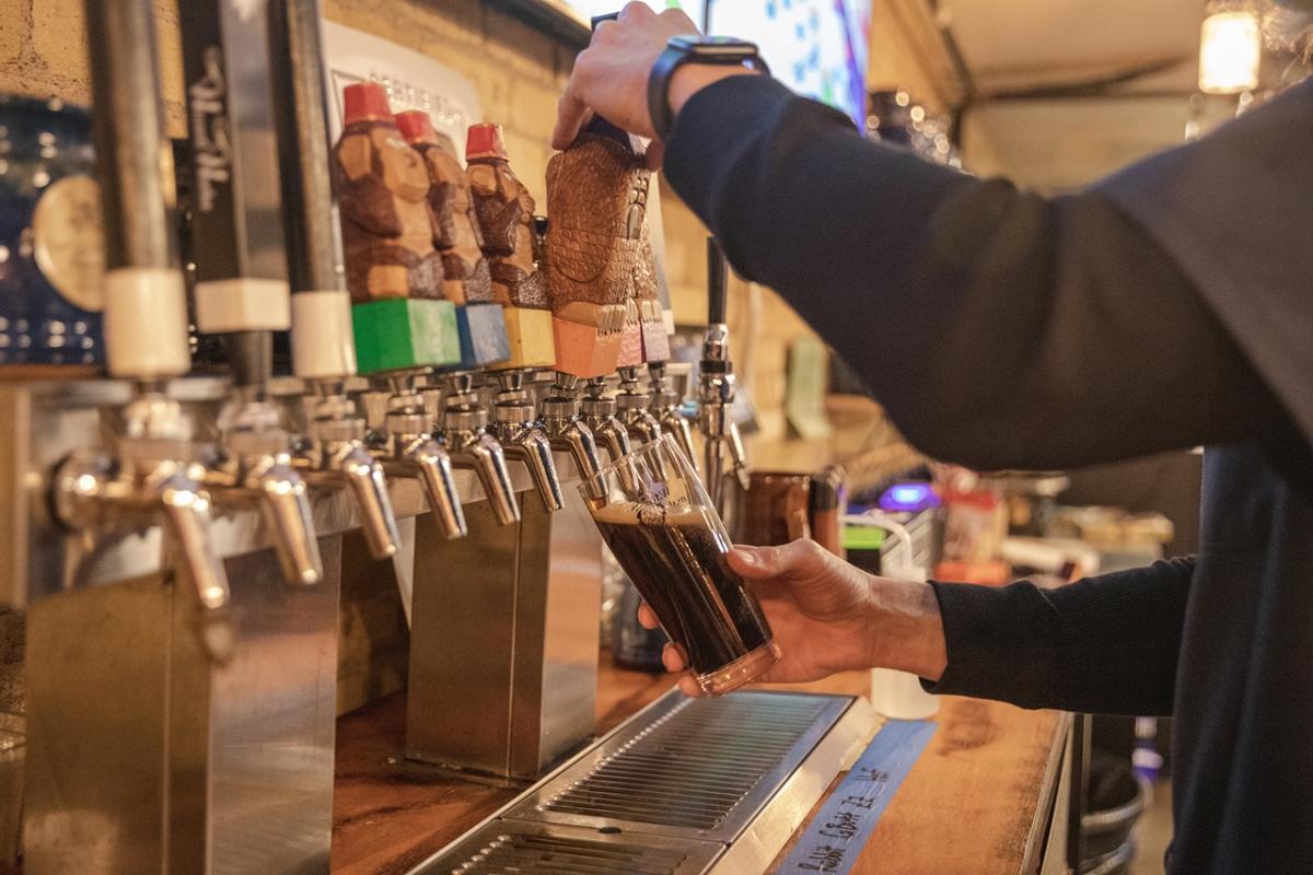 Bartender pouring a pint of beer at Wizard Works Brewing