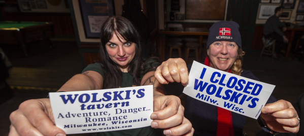two women holding "I Closed Wolski's" stickers