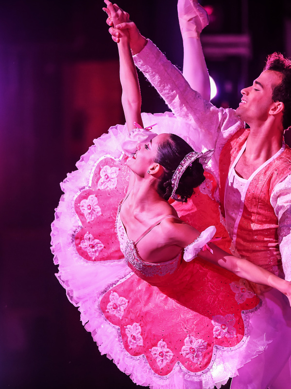 male and female performer pose on stage